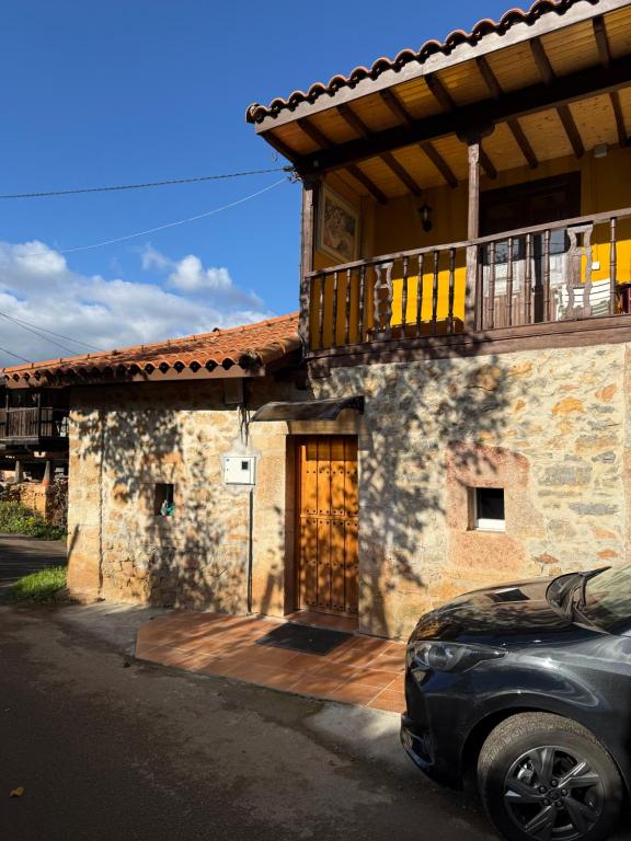 a house with a balcony and a car parked in front at Malva in Grado