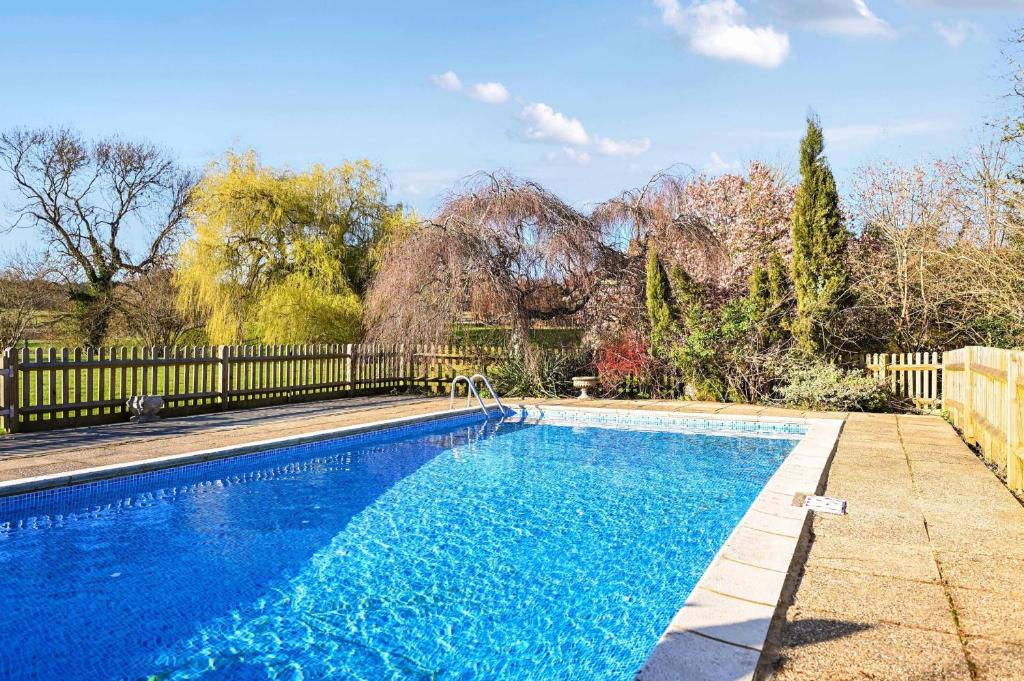 a swimming pool in a yard with a fence at Blackham Farm in Hartfield