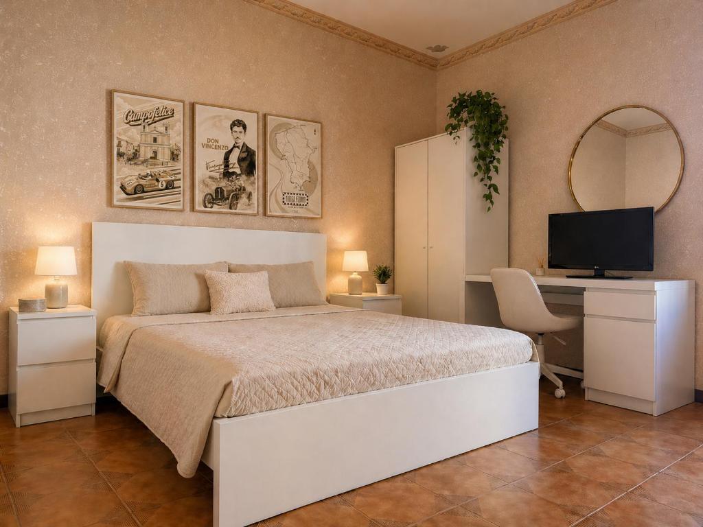 a bedroom with a bed and a desk and a television at Torre Florio in Campofelice di Roccella