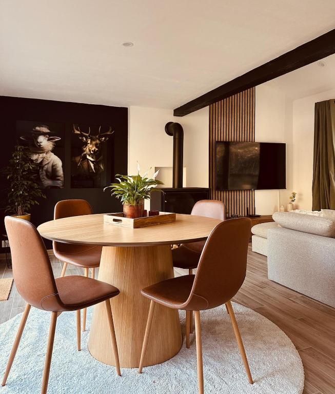 a living room with a wooden table and chairs at Nid cosy en forêt in Blaimont