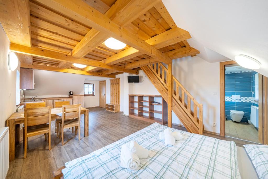 a room with a bed and a table and a kitchen at Apartmány Studený in Kunratice