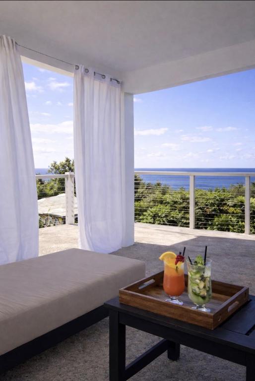 a bedroom with a bed and a view of the ocean at Purevibe Horizon House Ocean View Villa Port Antonio in Port Antonio