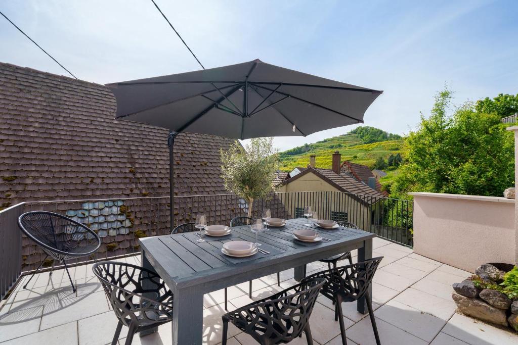a table and chairs with an umbrella on a patio at Kaisers Haus in Vogtsburg
