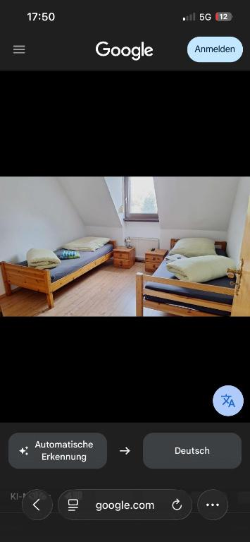 a picture of a bedroom with two beds at E&B Pension in Ganderkesee
