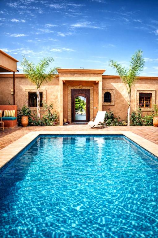 a swimming pool in front of a house at Villa Dar Nata in Tougouana