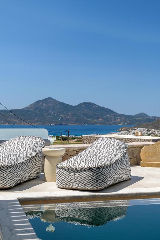 two pillows sitting next to a pool of water at Hilltop Suites Milos in Mytakas