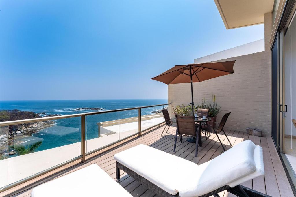 a balcony with a table and chairs and an umbrella at 1083 - Cosmo 3A3 in Tangolunda
