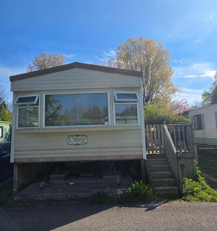 a tiny house sitting on top of a wooden ramp at Twin Ayre Cabin Retreat Welshpool in Welshpool