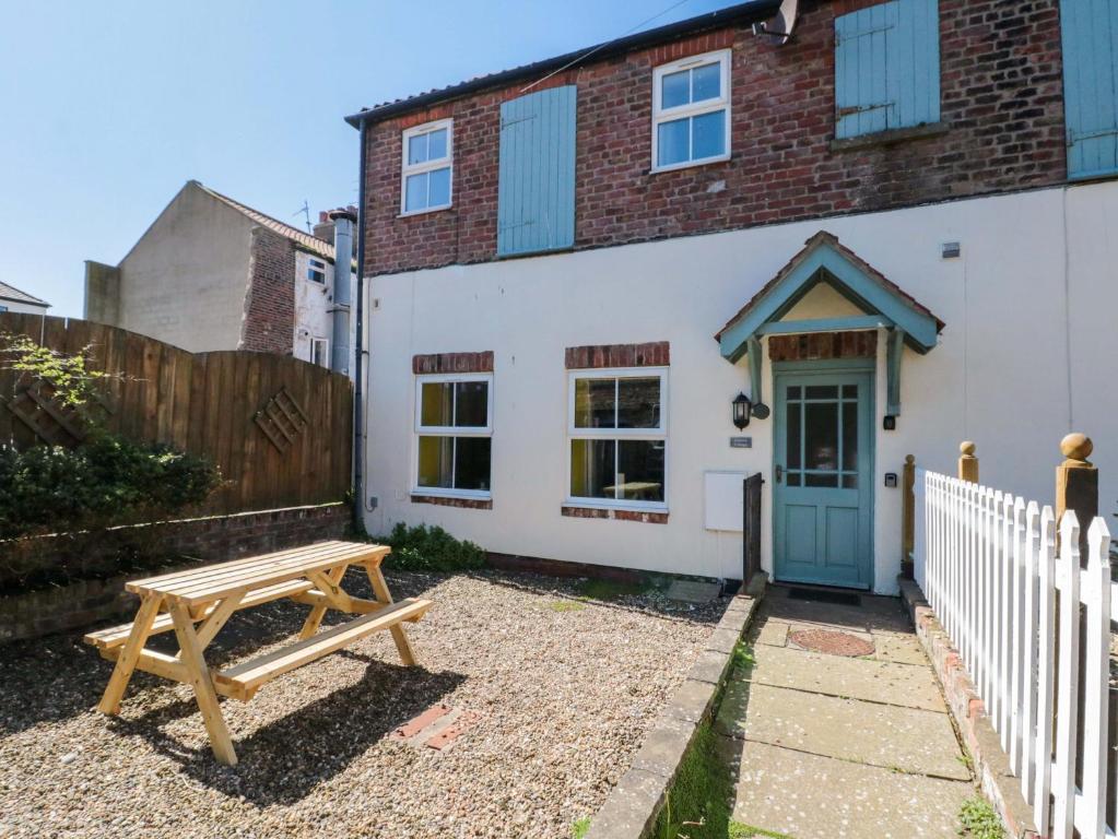 a house with a picnic table in front of it at Farriers Cottage in Bridlington
