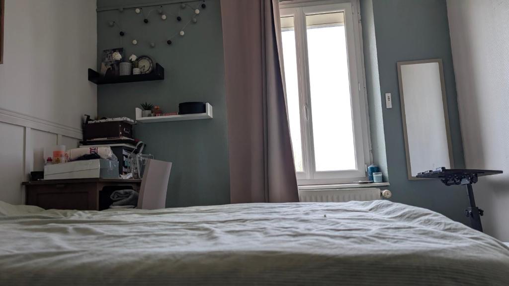 a bedroom with a white bed and a window at Chambre studio in Sublaines