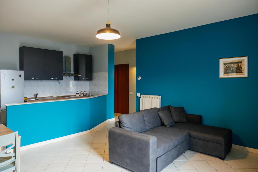 a living room with a couch and a blue wall at ll Paiolo Magico in Montella