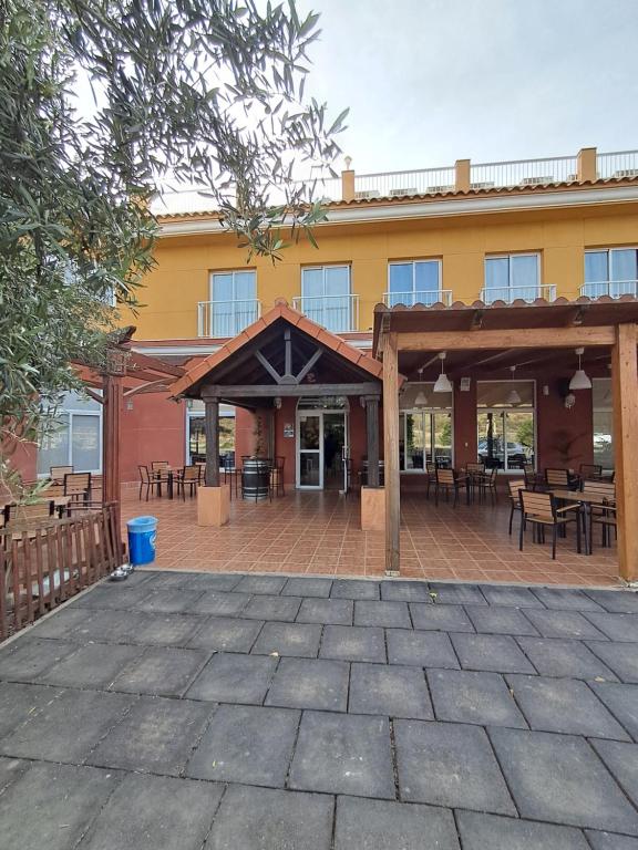 an outdoor patio with tables and chairs in front of a building at Hotel venta de Tébar in Águilas