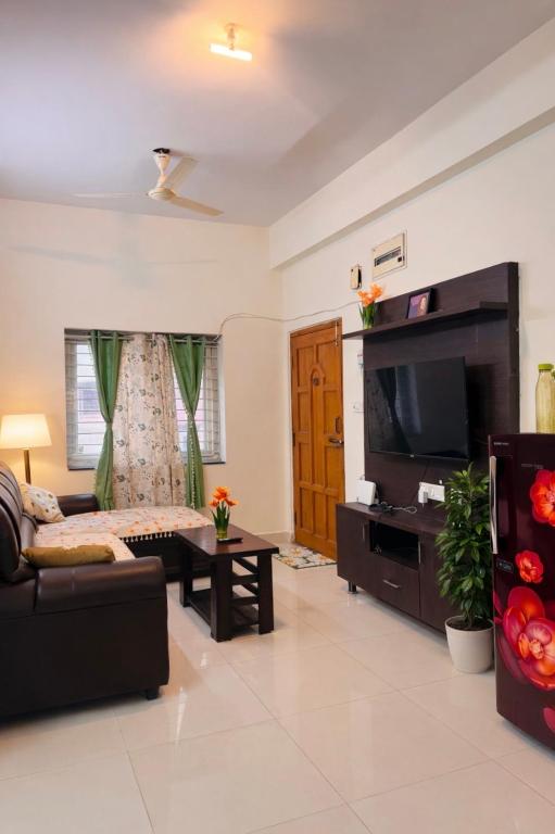 a living room with a couch and a flat screen tv at Deccan Homes Kondapur in Hyderabad