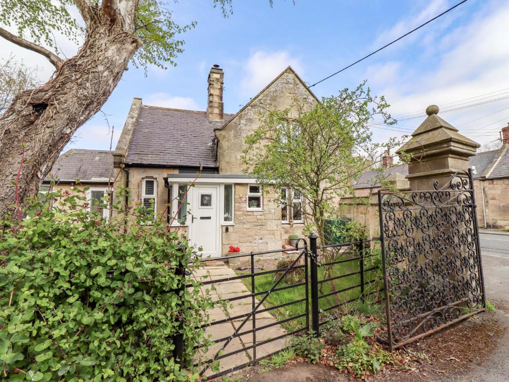 an old house with a gate in front of it at The Lodge in Alnwick