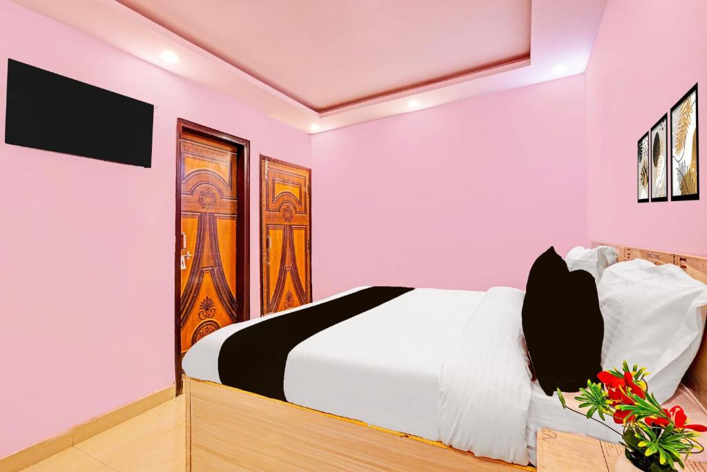 a bedroom with a white bed and paintings on the wall at Hotel O Sky House Residency in New Delhi