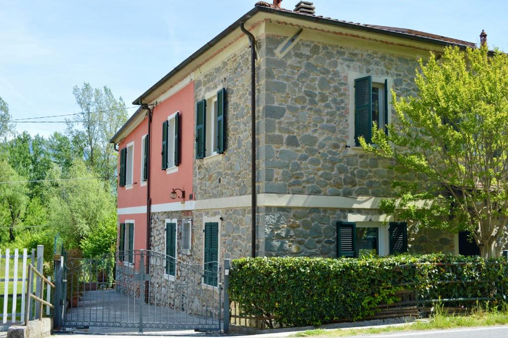 an old stone house with a fence in front of it at Il marchese Malaspina con idromassaggio in Mulazzo
