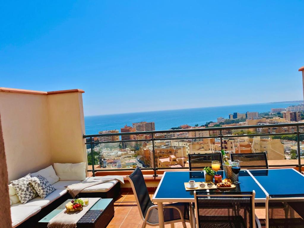 a balcony with a couch and tables and the ocean at Espacioso Dúplex con terraza y vistas in Aguadulce