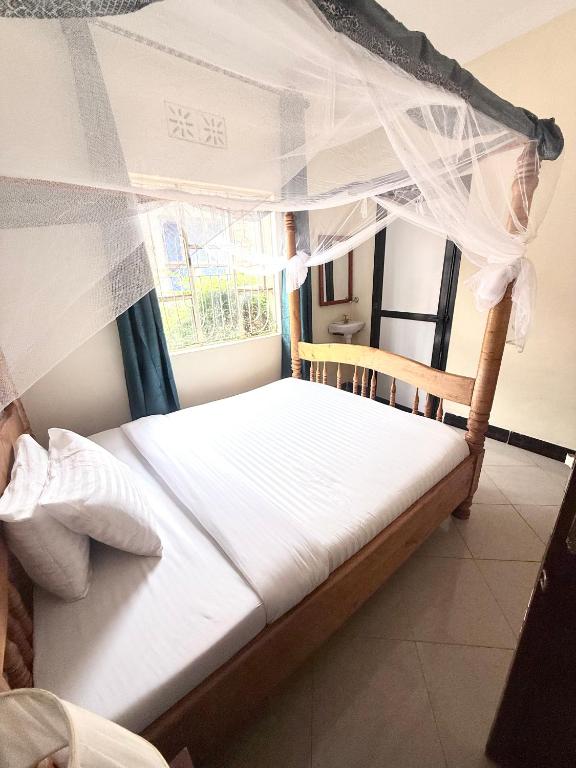 a bedroom with two beds with mosquito nets at Biez Homestay in Karatu