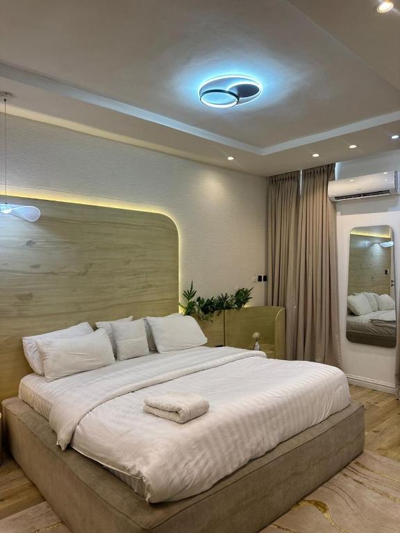 a bedroom with a large bed with a large white bedvisor at Vluxuries in Lekki