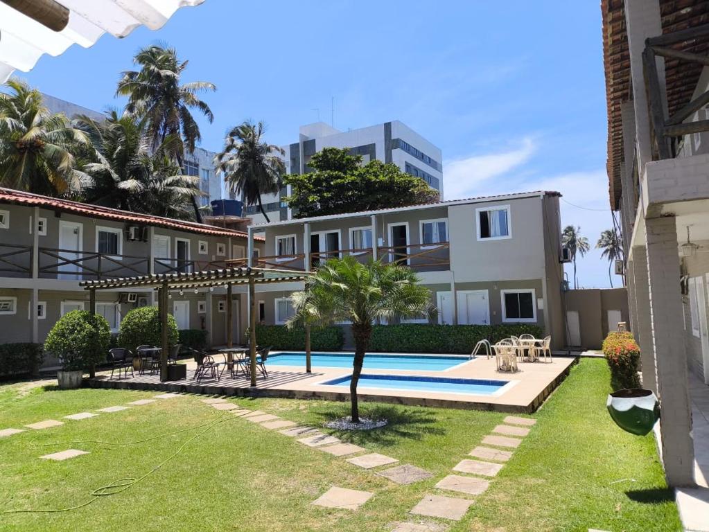 a building with a yard with a swimming pool at Pousada das Araras in Maceió