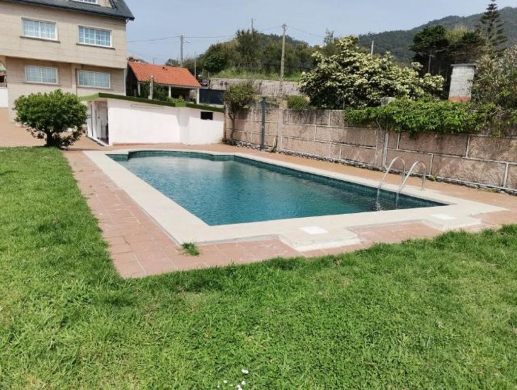 a swimming pool in a yard next to a house at Casa Mar de Viladesuso in Oia