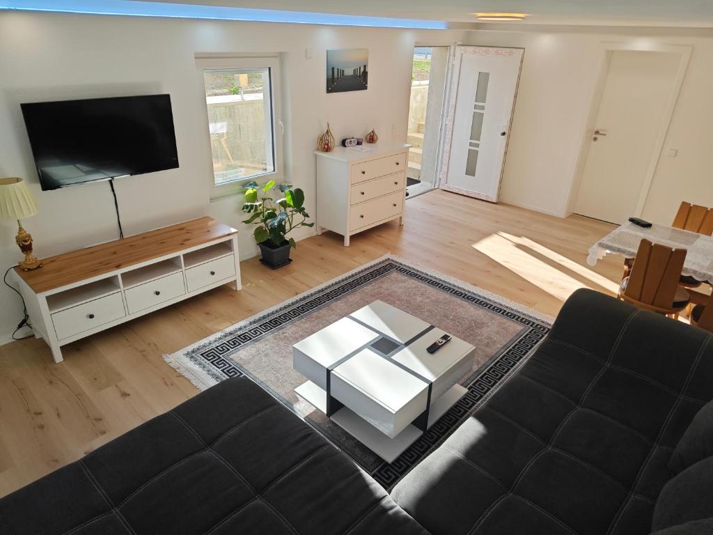 a living room with a couch and a flat screen tv at Ferienwohnung ERSO in Wutöschingen