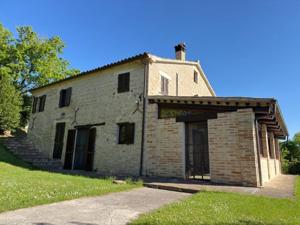 an old brick building on a grassy hill at Prana Hill in Cupramontana