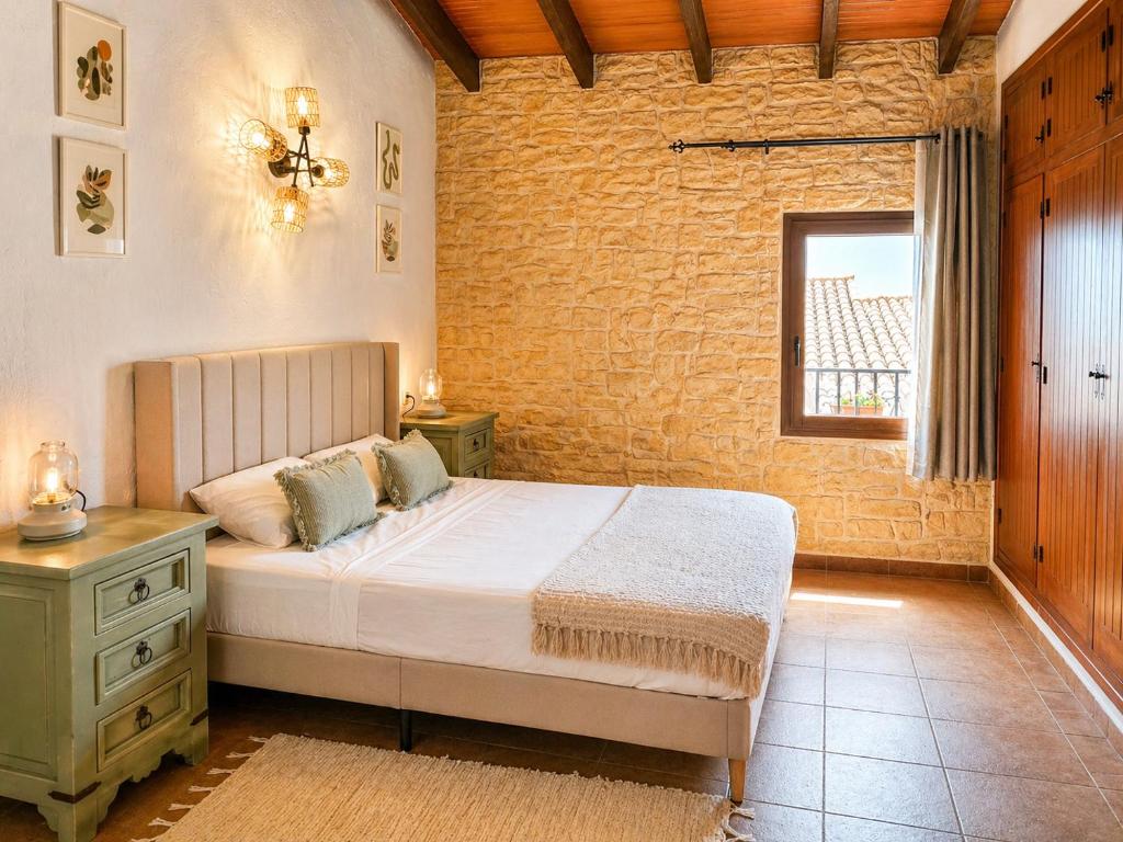 a bedroom with a bed and a brick wall at La Rustiqueta Javea terraza BBQ casco antiguo in Jávea