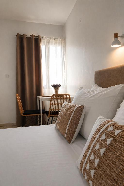 a bedroom with a bed with a table and a window at Filoxenia in Platy