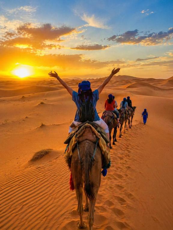 a group of people riding horses in the desert at Sahara Desert Apartment with Camel Tours & Free WiFi in Merzouga