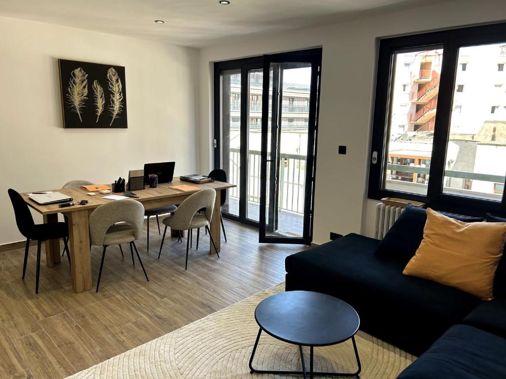 a living room with a couch and a table at L'Escale Gare Châteaucreux avec Garage in Saint-Étienne