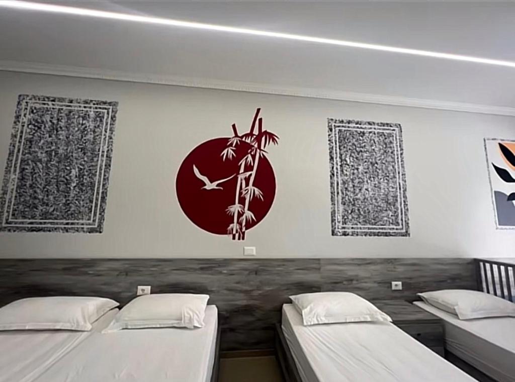 a room with two beds and a clock on the wall at Helix Apartments in Fier