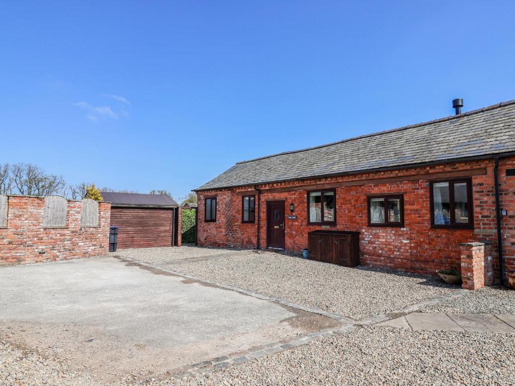 a brick building with a driveway in front of it at Elwy Cottage in St Asaph
