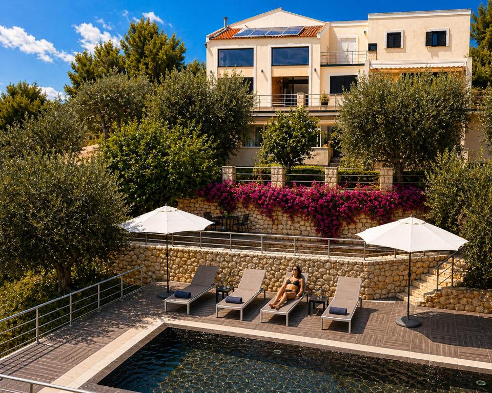 a woman sitting on a chair next to a swimming pool at Zia Nì Boutique Suites in Peschici