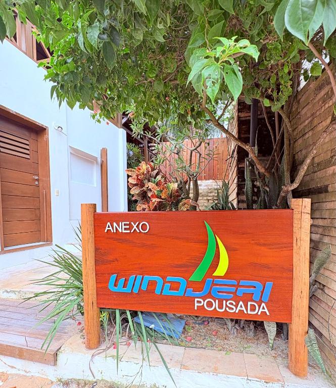 a wooden sign in front of a building at Anexo à Pousada WindJeri in Jericoacoara