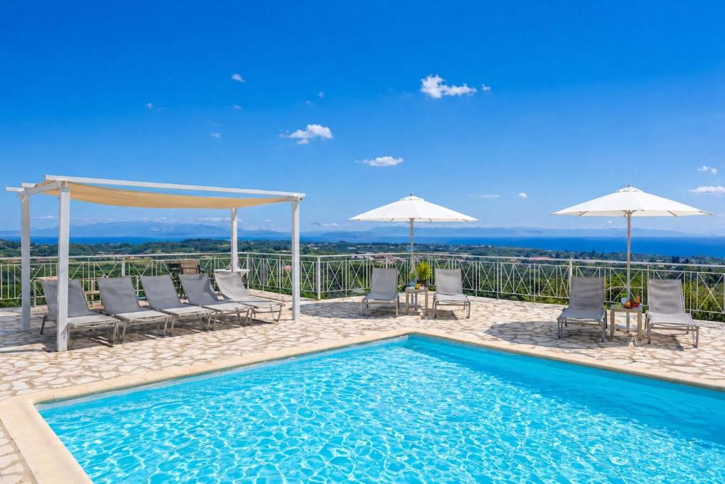 a swimming pool with chairs and umbrellas at Ionian Balcony Hotel Apartments in Khavdháta