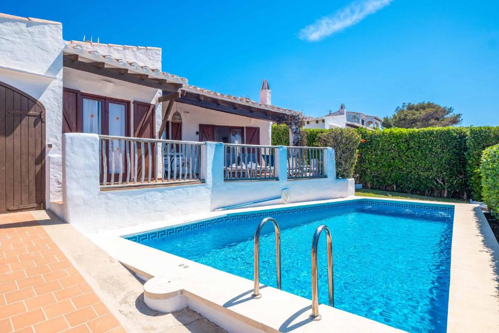 a swimming pool in front of a house at Villa Binisol in Binibeca