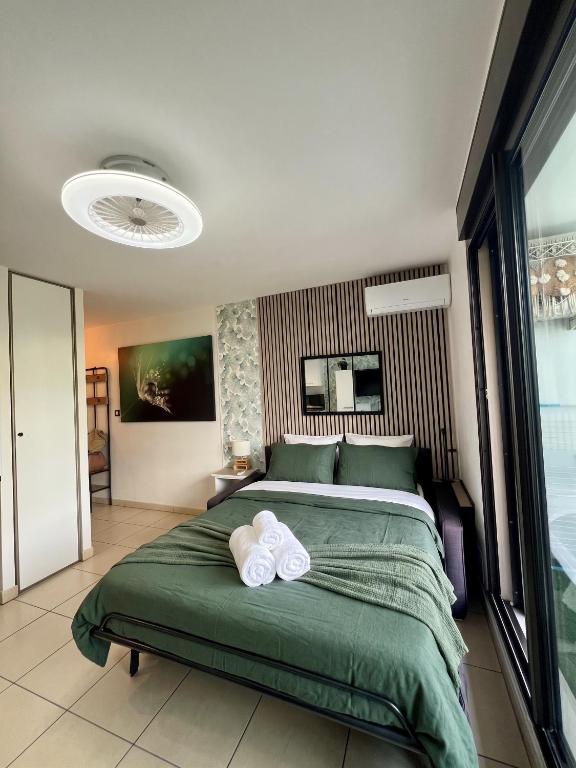 a bedroom with a bed with two towels on it at Le Lobellia à Sainte Clotilde centre in Sainte-Clotilde