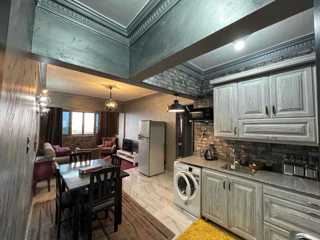 a kitchen and living room with a table and a refrigerator at Dora home in Cairo