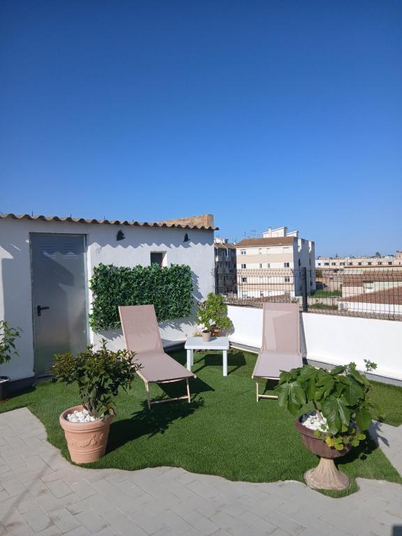 a patio with two chairs and a table on a roof at Lo Racó del Delta in Sant Jaume d'Enveja
