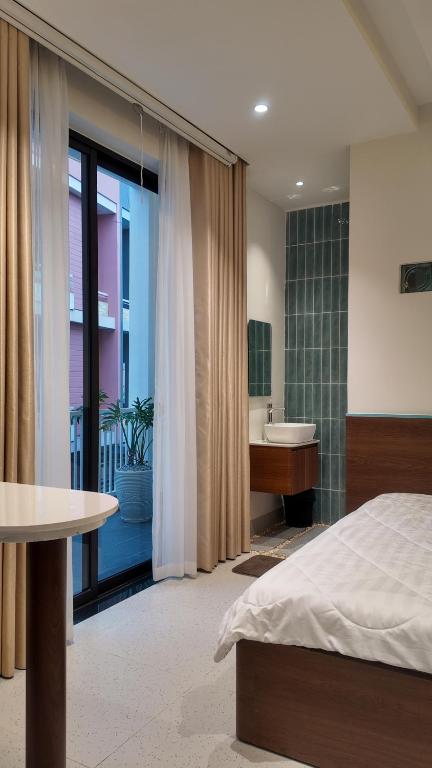 a bedroom with a bed and a bathroom with a sink at Mik Stay 2 in Danang