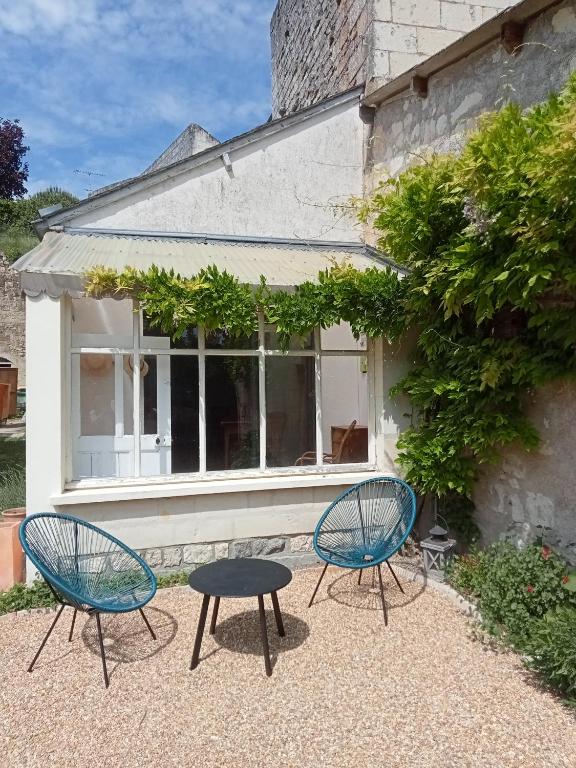 two chairs and a table in front of a building at Gite du Vidame in Montsoreau
