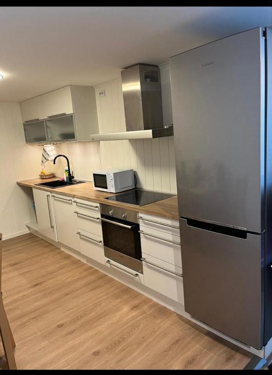 Eine Küche mit Edelstahlgeräten und Holzböden in der Unterkunft Malinki Apartment in Ålesund
