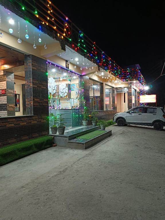 a car parked in front of a building with christmas lights at RK Residency Hotel & Resturant in Ukhimath