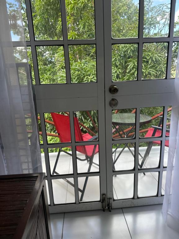 an open door with a red chair outside at Moulin A vent apartment in Monchy