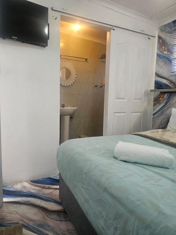 a bedroom with a bed and a bathroom with a shower at 1krom str bellville boston in Bellville