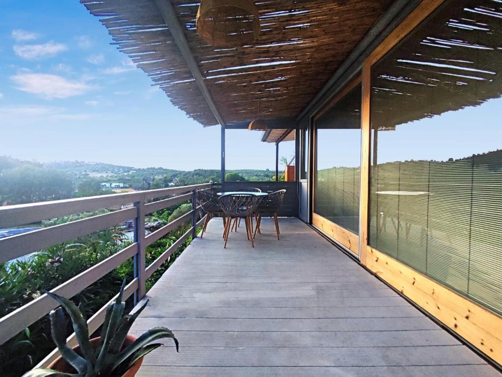 a balcony of a house with a table and chairs at Agave by Aloe Residence Possidi in Possidi