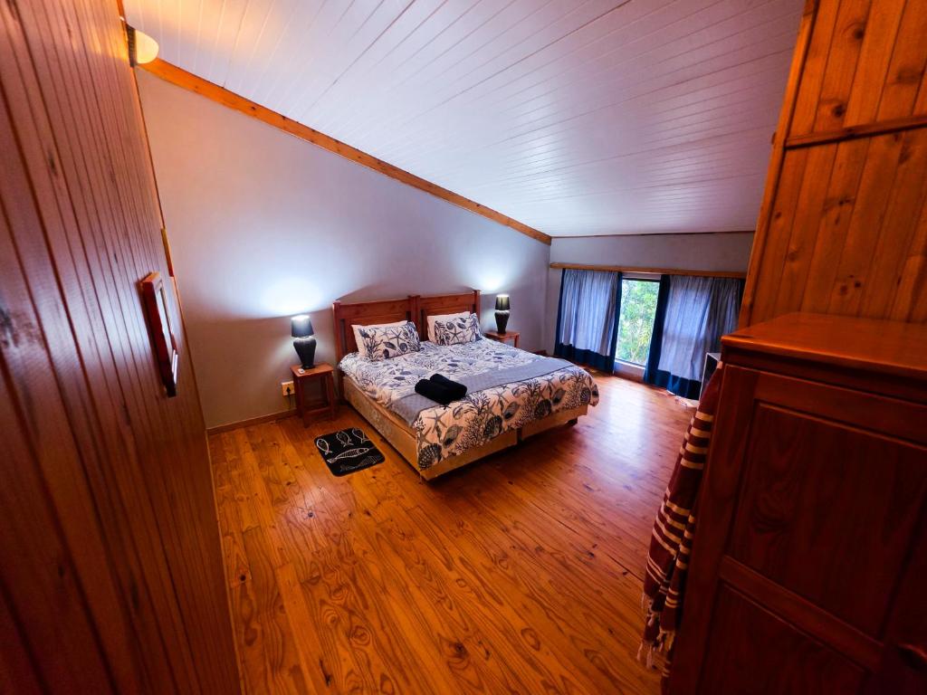 a bedroom with a bed and a wooden floor at Reefteach Lodge in Sodwana Bay