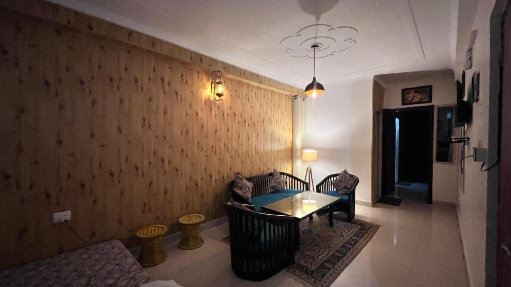 a living room with a table and a wall at Premium 2BHK near Kainchi Dham in Bhowāli