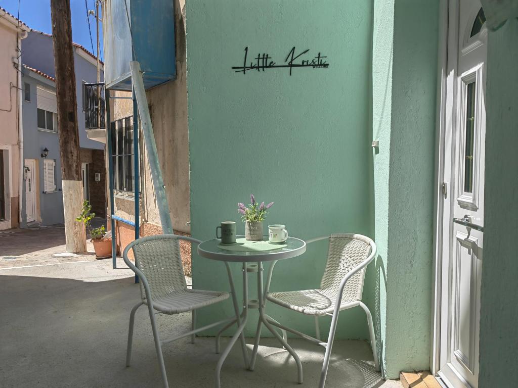 a table and chairs on the side of a building at Little Kristi in Palaiókastron